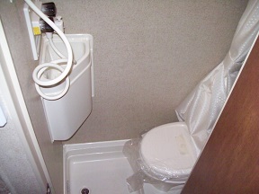 The wet bath consists of a toilet and sink inside of the shower stall.