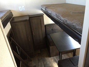 The small dinette makes the bottom bunk, and the top bunk folds down from the wall above.