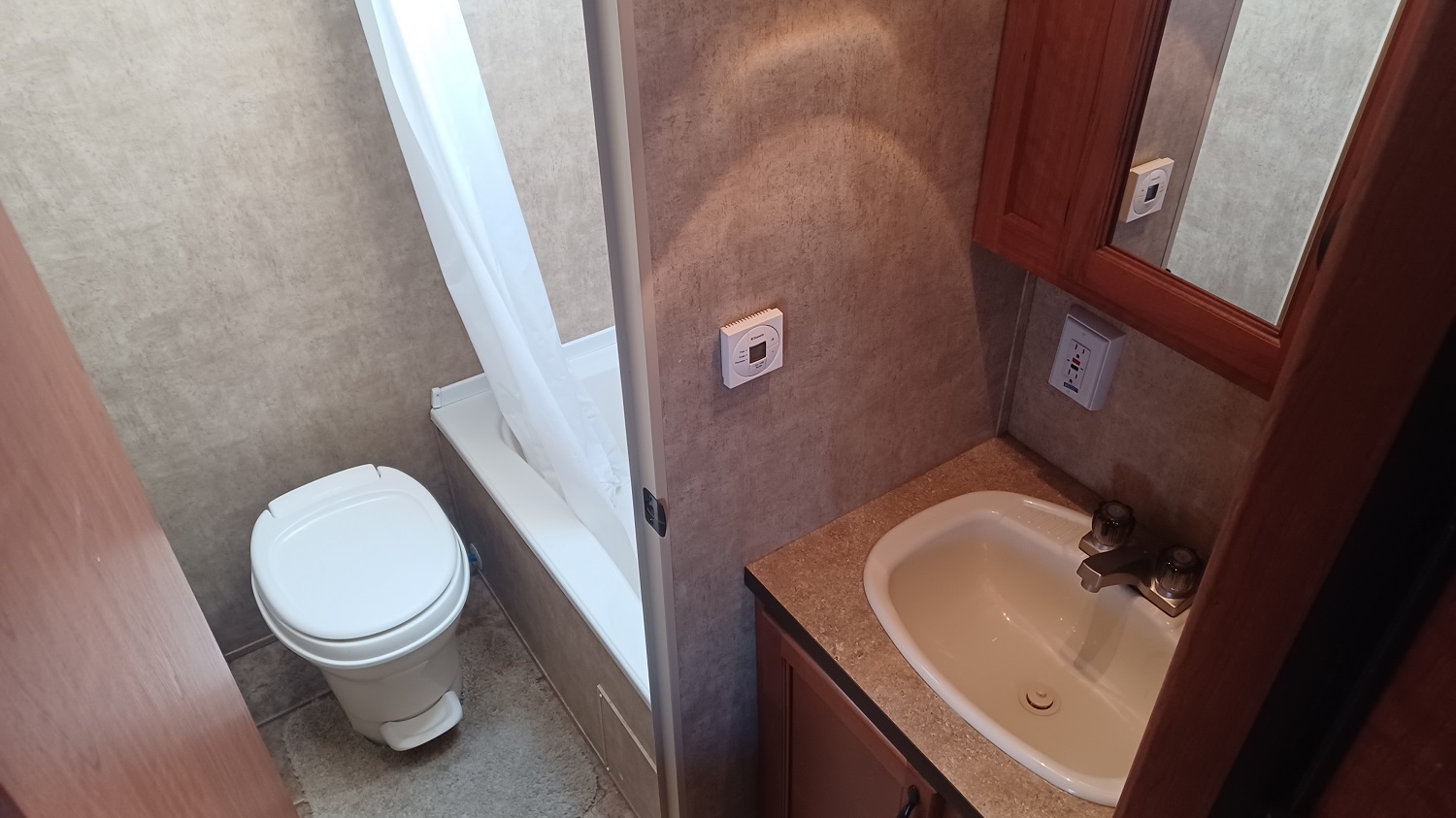 Toilet and shower behind privacy door, lavatory sink accessible outside of privacy door