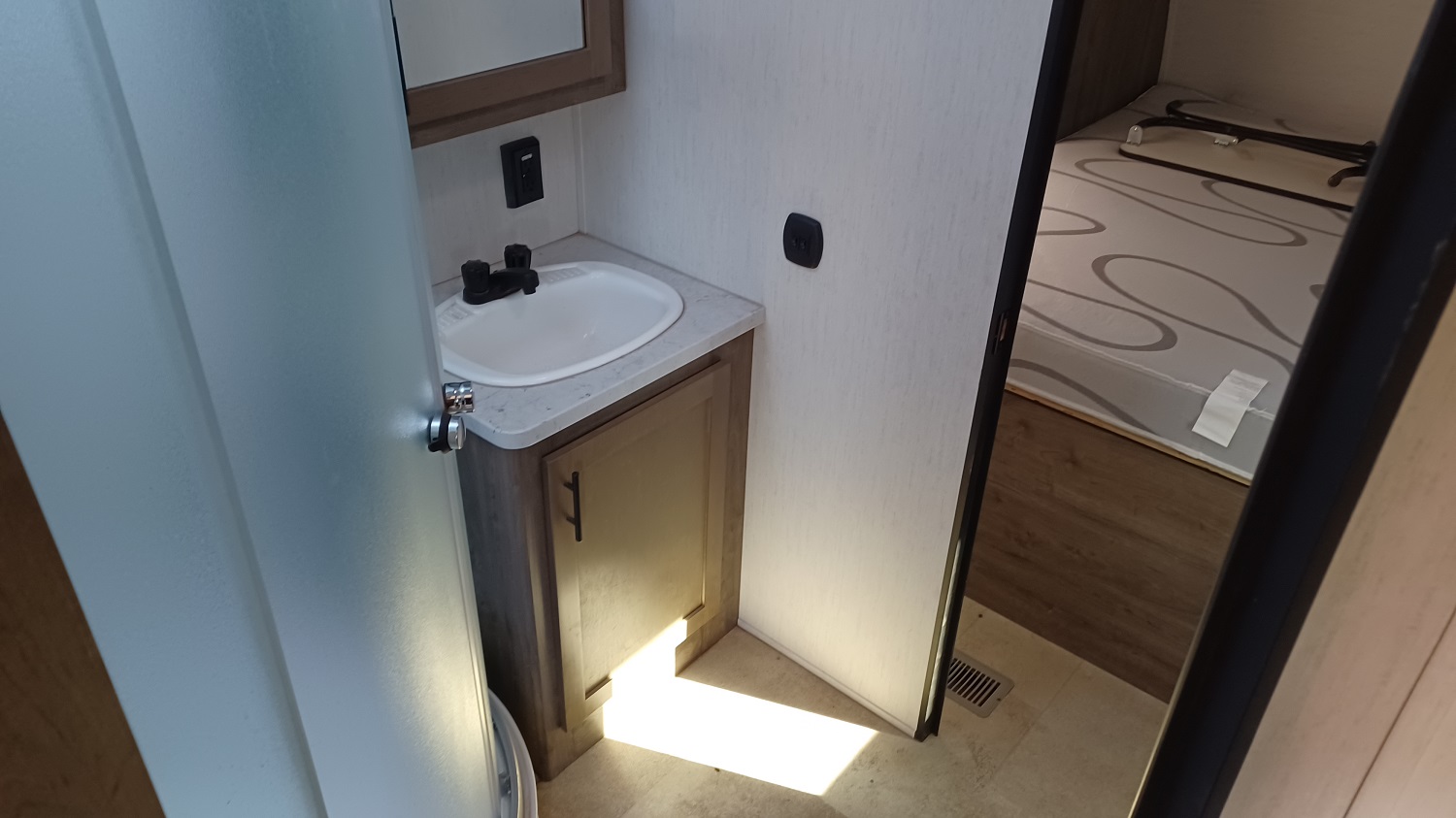 the bathroom separates the garage area from the bedroom